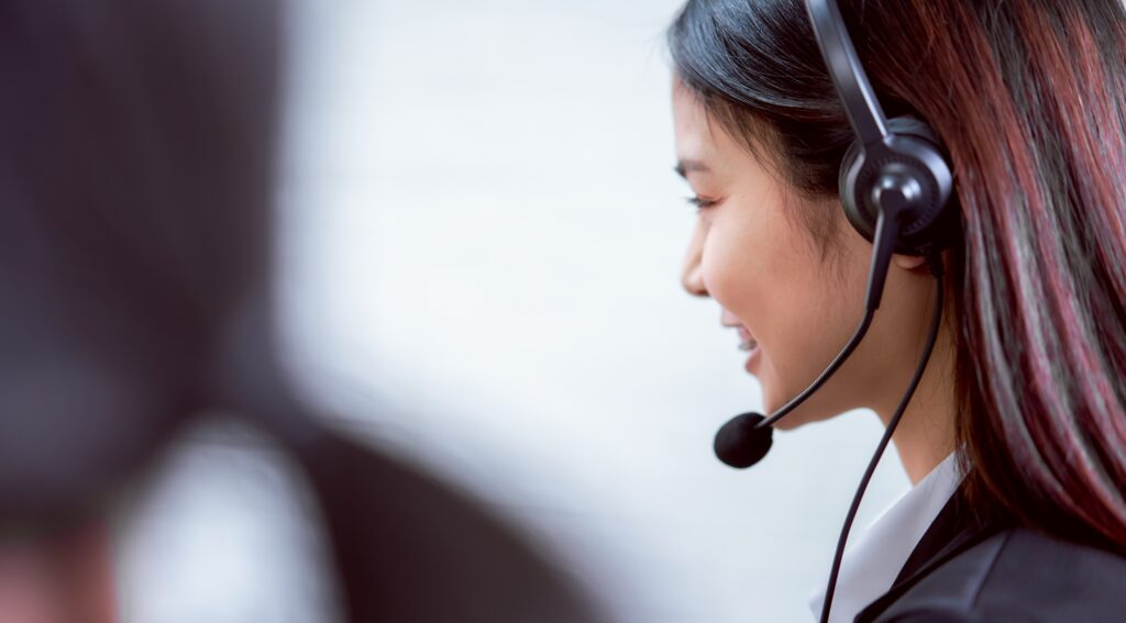 Woman with headset smiling during consultation with telecoms provider uk