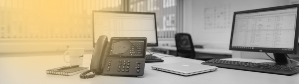 Office technology setup with desk phone, laptop and network equipment for business communications using business phone system features