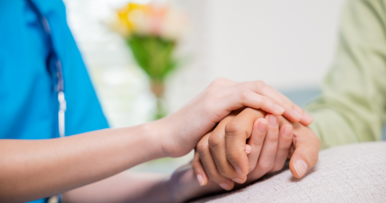 Care Home Phone Systems UK & Ireland supporting compassionate resident care with nurse holding elderly resident’s hand in modern care home