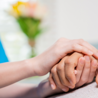 Care Home Phone Systems UK & Ireland supporting compassionate resident care with nurse holding elderly resident’s hand in modern care home